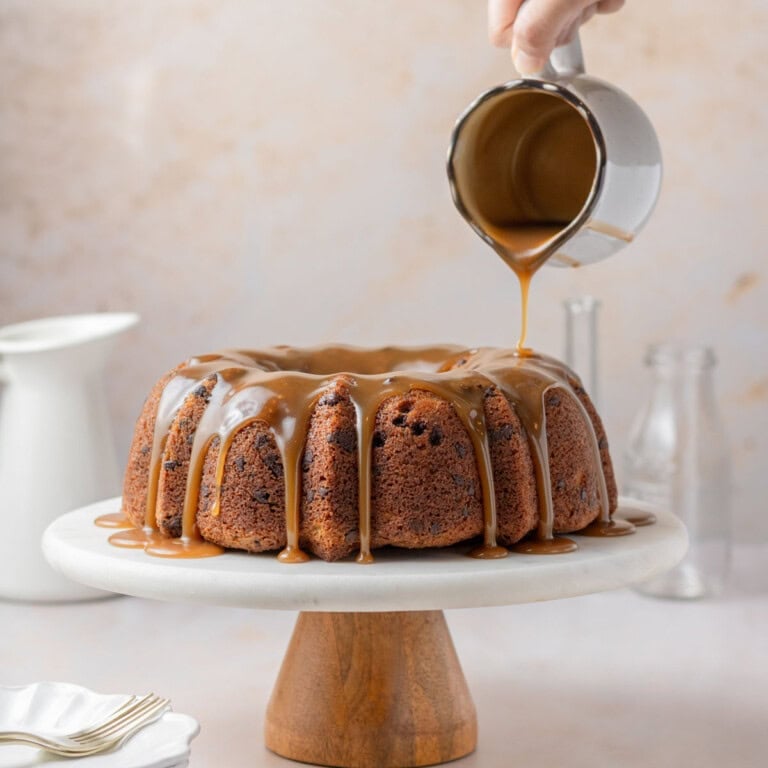 featured - chocolate chip banana bundt cake with butterscotch glaze being poured over it