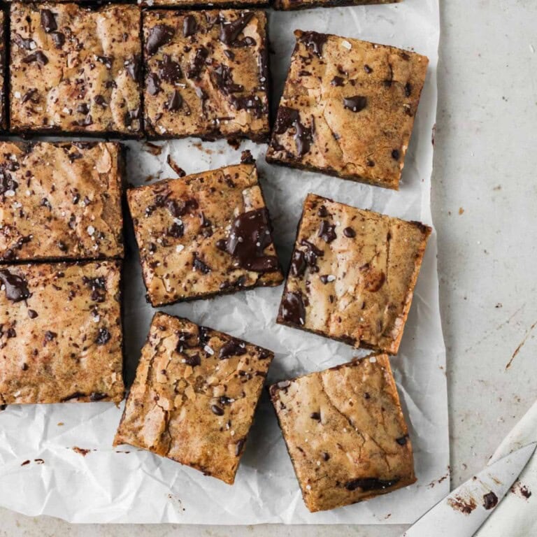 brown butter chocolate chunk blondies spread out on a piece of parchment paper