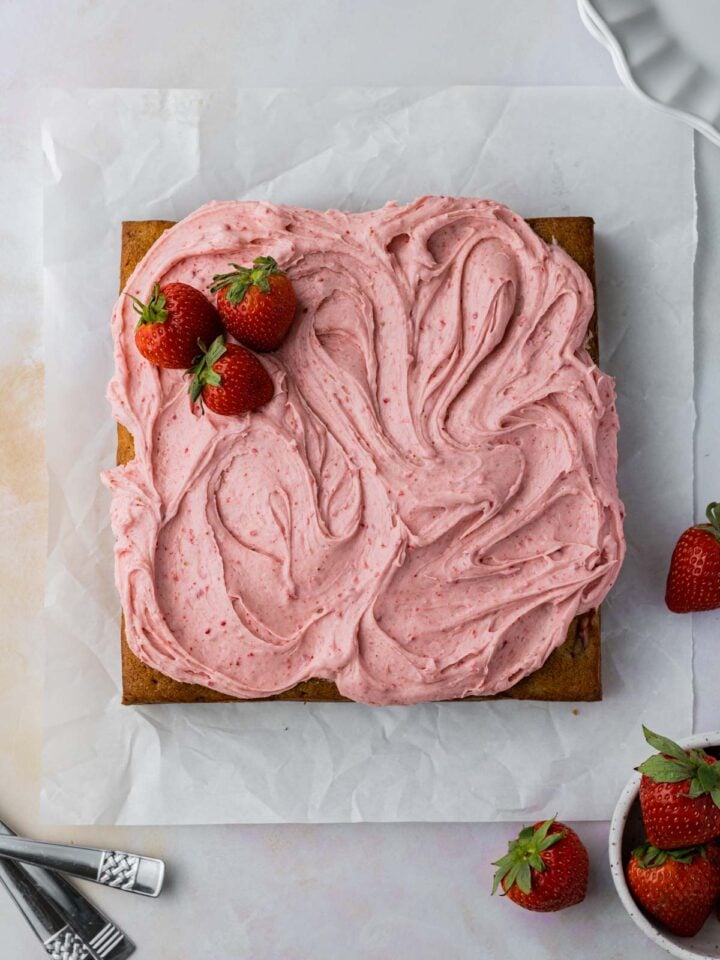 frosted strawberry banana cake with strawberries on top
