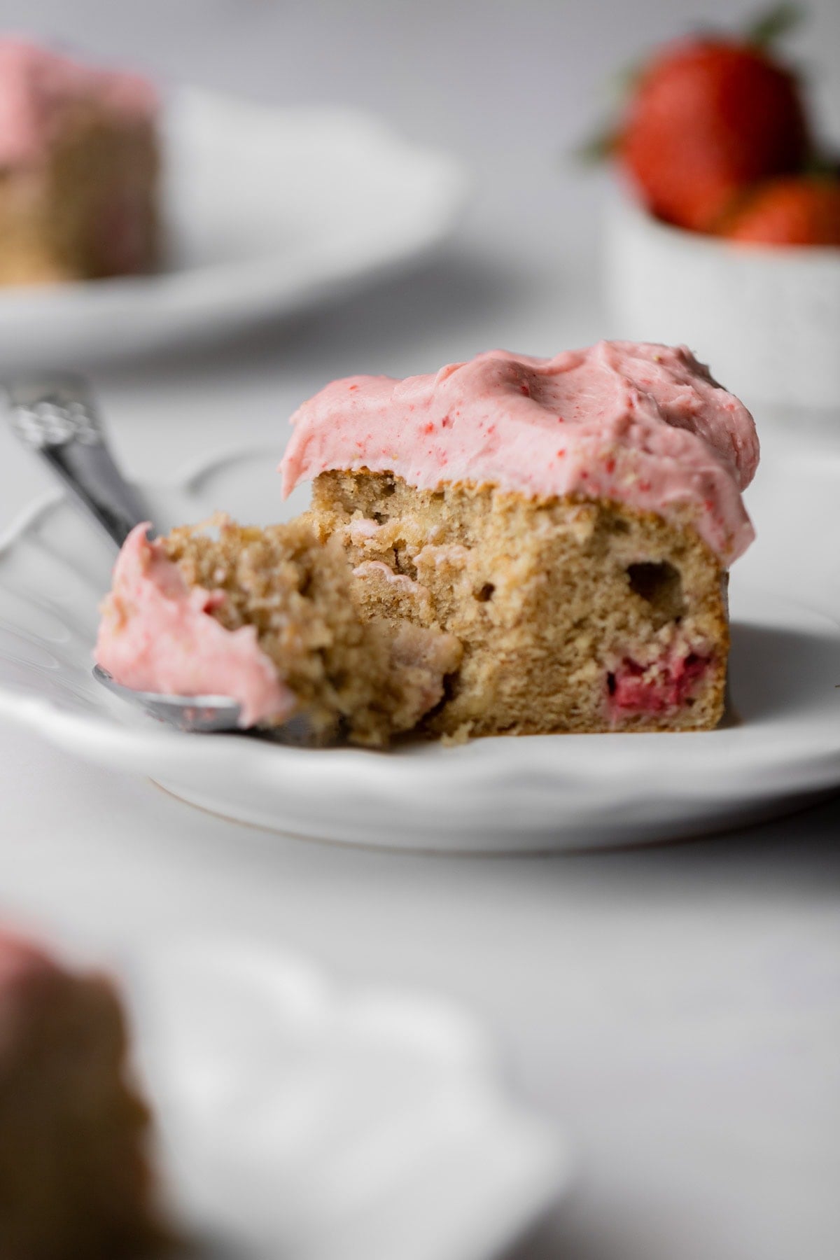 close up of strawberry banana cake with a piece taken out with a fork