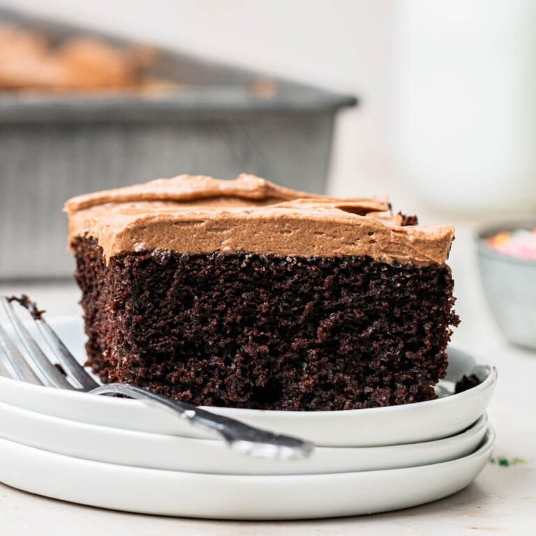 chocolate sheet cake on a stack of plates