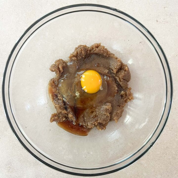 add the brown butter to a bowl, then mix with the sugars and add the egg and vanilla extract.