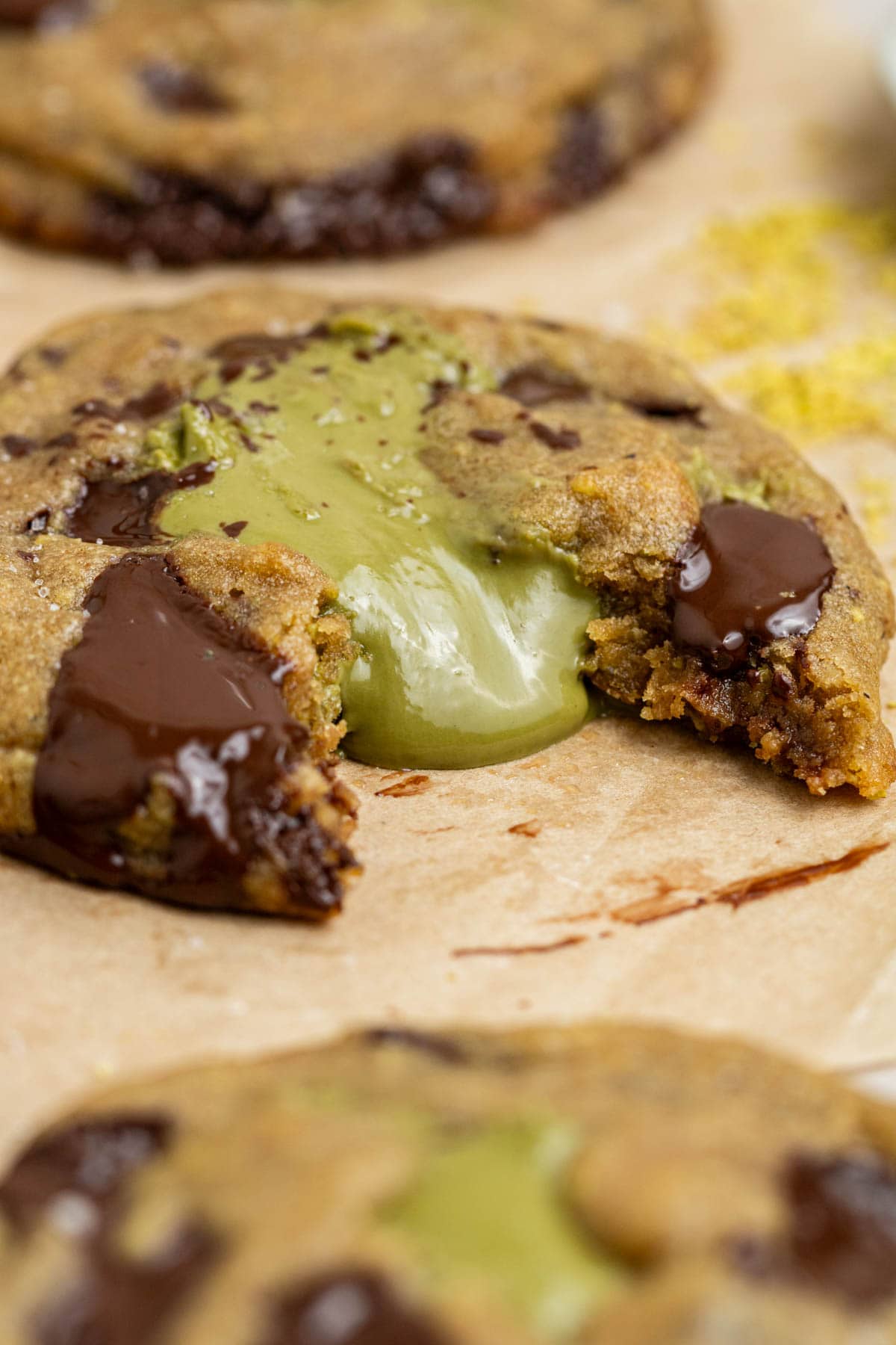 close up of pistachio cream oozing out of chocolate chip cookie