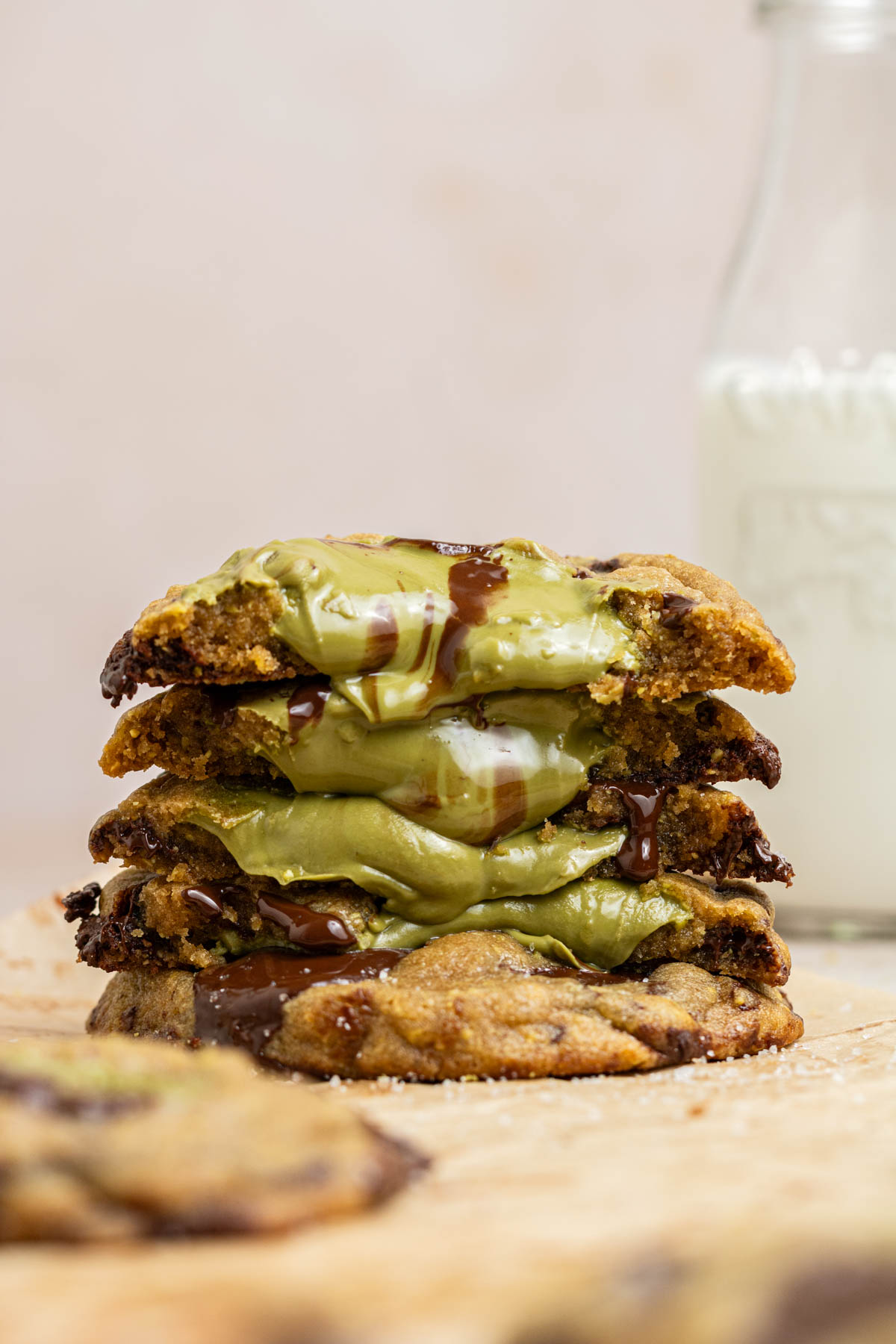 stack of chocolate chip cookies stuffed with pistachio cream oozing out of the cookies