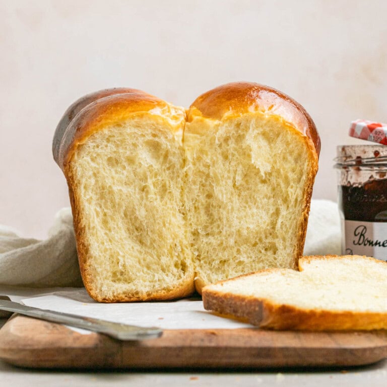 brioche loaf with a slice cut out on a cutting board
