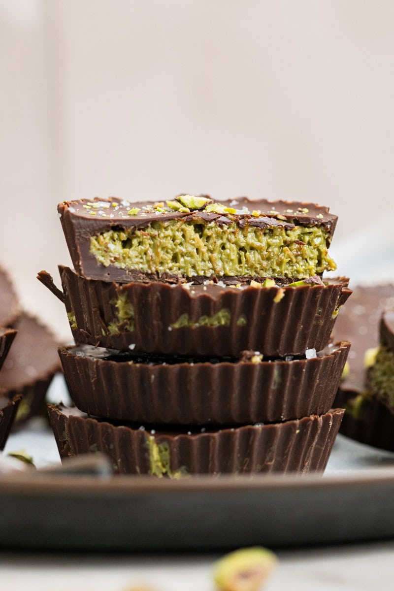 stack of dubai chocolate bar on top of a serving platter with crushed pistachios and sea salt