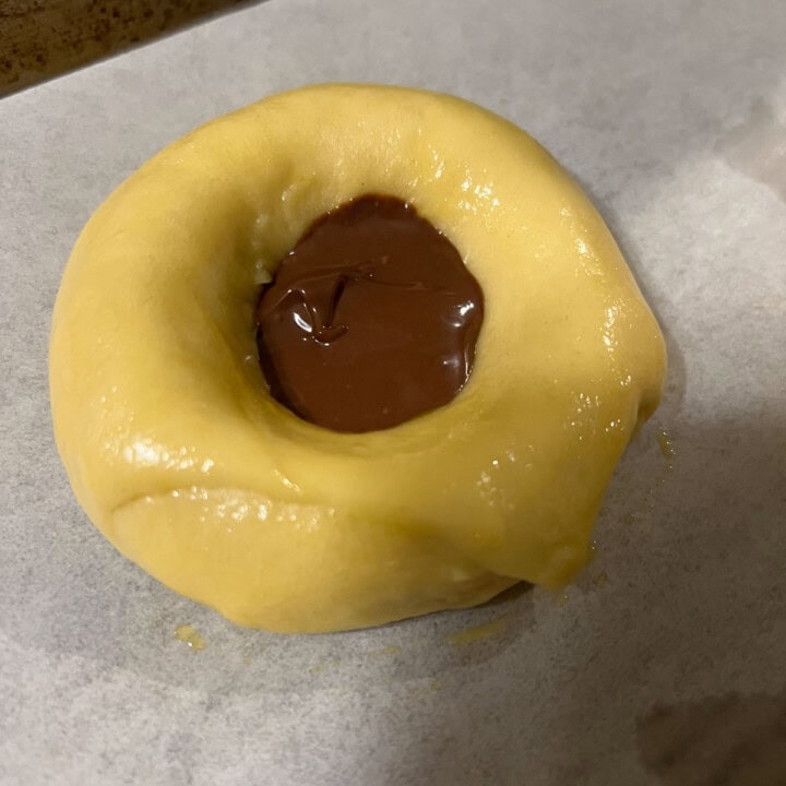 adding chocolate to bottom of indent of brioche bun