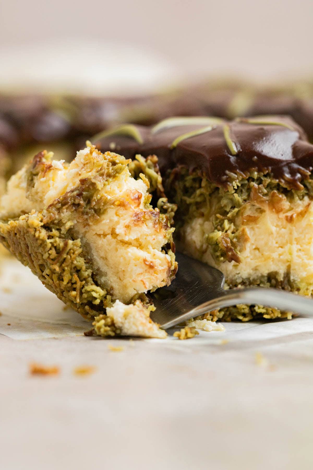 fork cutting into slice of cheesecake bar