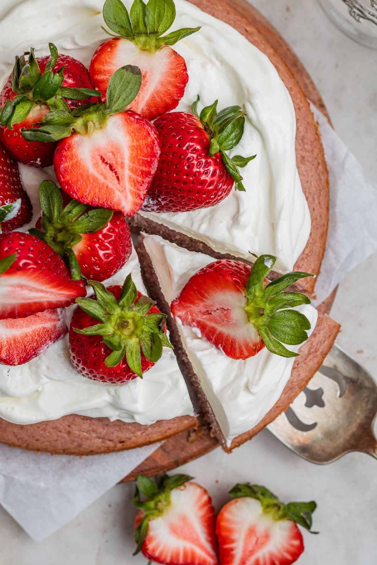 strawberry cake with a slice being taken out