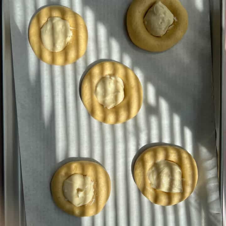 adding cream cheese to brioche buns