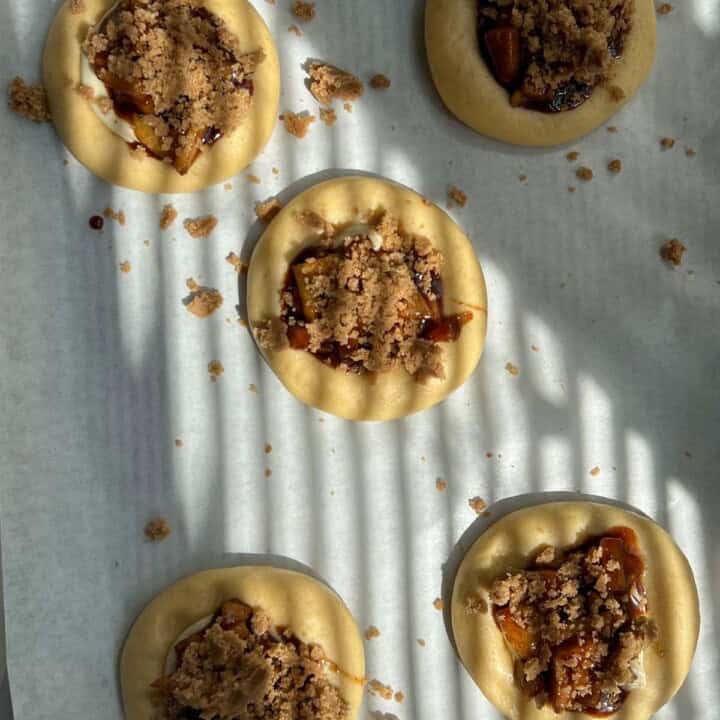 adding crumble topping to brioche buns