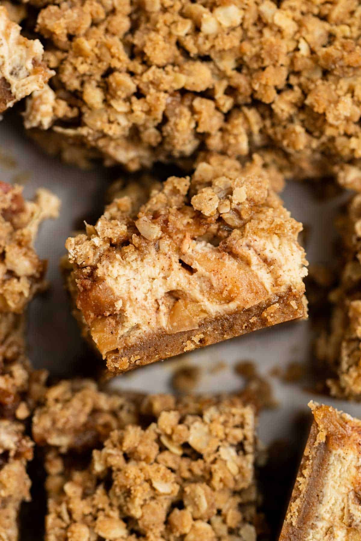 Apple crisp cheesecake bar with crisp topping and graham cracker crust and spiced apples