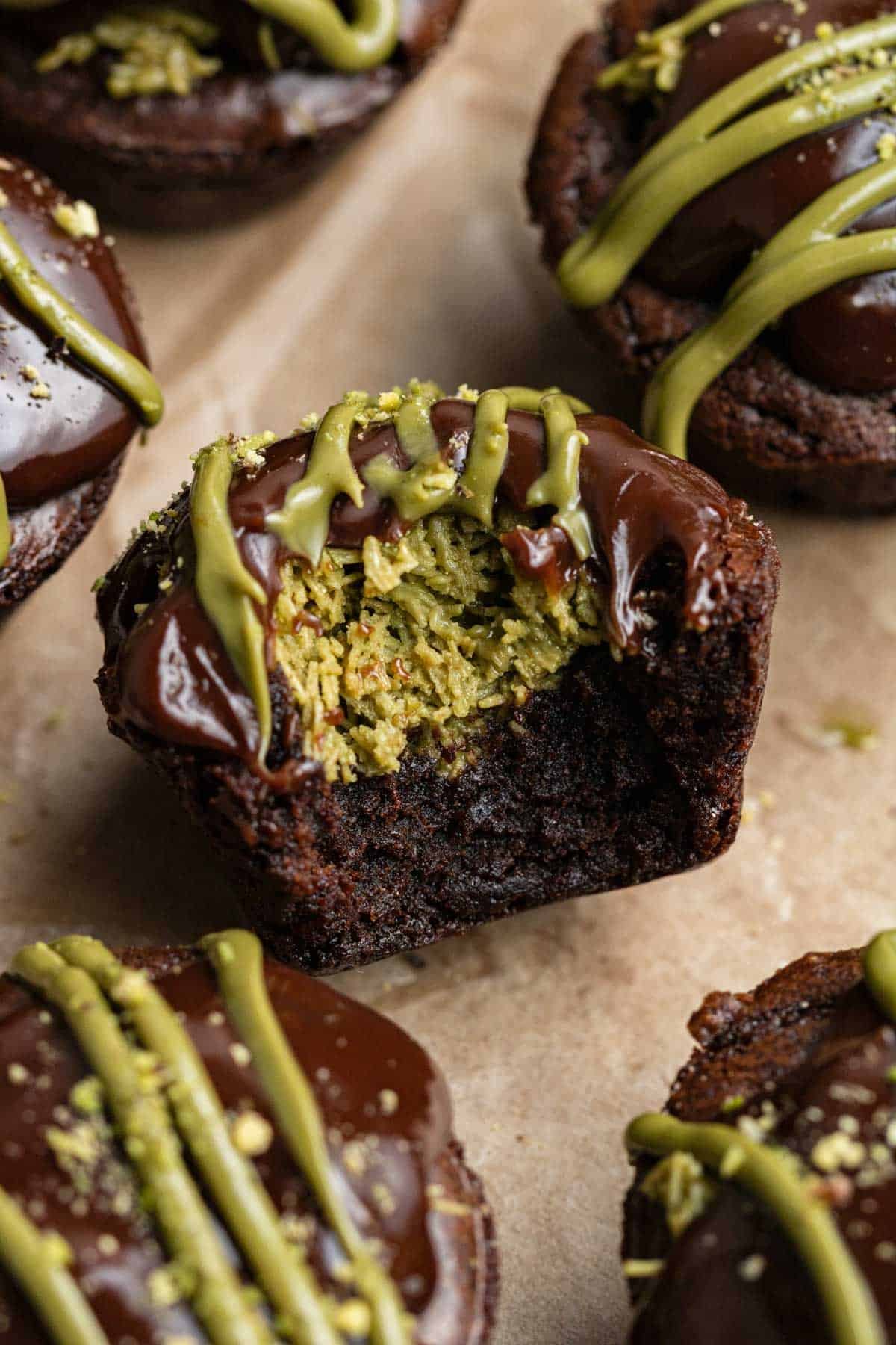 bite taken out of a pistachio brownie showing the kunafa pistachio center