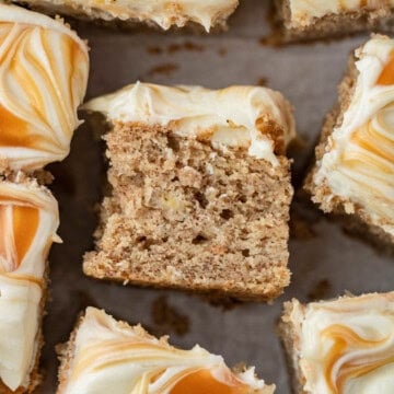 spiced banana cake with cream cheese frosting and topped with swirls of caramel sauce