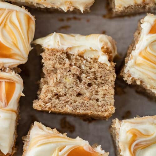 spiced banana cake with cream cheese frosting and topped with swirls of caramel sauce